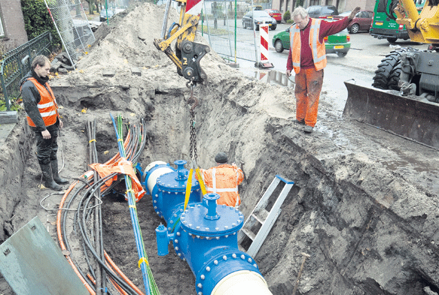 Medewerkers van Van Voskuilen uit Woudenberg plaatsen een afsluiter op het waternet aan de Hoenderparkweg in Apeldoorn. Foto: APA/Sjef Prins