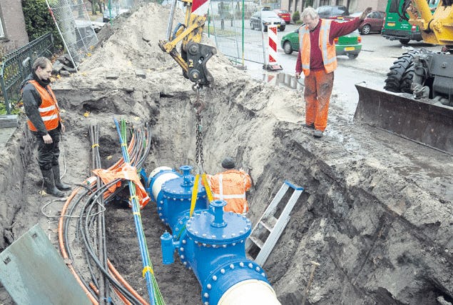 Medewerkers van Van Voskuilen uit Woudenberg plaatsen een afsluiter op het waternet aan de Hoenderparkweg in Apeldoorn. Foto: APA/Sjef Prins