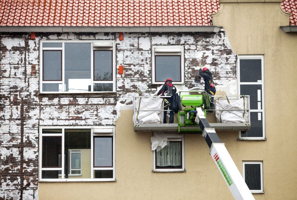 de gevel wordt met een schop ontdaan van piepschuim voordat het gebouw gesloopt kan worden. Er wonen nog twee gezinnen in die er niet uitwillen. Daar wordt omheen gewerkt