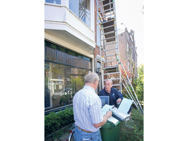 Inspecteur Baneman waarschuwt zelfstandig ondernemer Tom Cahill: "De afstand tussen werkvloer op de steiger en de gevel is plaatselijk meer dan 15 centimeter. Die gedeelten moeten worden beveiligd." Foto: Peter van Mulken