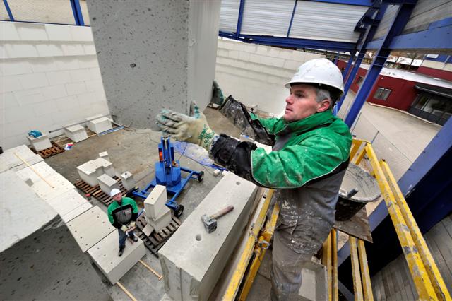 ALMELO – Driehonderd kilo zware kalkzandsteenblokken omzomen in twaalf lagen de toekomstige poppodiumzaal van De Talentenfabriek in Almelo. Onder de overkapping van de vroegere machinaefabriek Brugman takelen bouwvakkers van Goossen Almelo de zwaargewichten met een kraantje omhoog. De geluidsisolatie van het gebouw krijgt extra aandacht vanwege de geplande optredens in de podiumzaal, waarin driehonderd bezoekers passen. In De Talentenfabriek komen verder oefenruimtes voor muziekbands, een studio, een audiovisuele ruimte, danszaal en kantoorruimtes. In de nieuwbouw komt Almelose vestiging van De Muziekschool Twente, die samen met de gemeente Almelo het inititiatief tot de bouw nam. Op de bovenverdieping van 800 m2 is ruimte voor startende creatieve ondernemers. Leferink Architecten in Denekamp maakte het ontwerp.