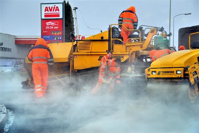 Regenbuien zorgen voor stoomvorming tijdens asfalteringswerkzaamheden op bedrijventerrein Turfkade in Almelo. Een ploeg van Temmink Infra en Milieu uit Oldenzaal werkt in totaal zo'n twee jaar aan de verbetering van het wegennet p het bedrijventerrein, steeds met tussenpozen. Vanwege het slechte weer beperkt het bedrijf zich nu tot het aanbrengen van de harde lagen, zodat het verkeer weer van de wegen gebruik kan maken. De deklagen volgen komend voorjaar. In totaal draait Temmink Indra en Milieu zo'n 14.000 ton asfalt op bedrijventerrein Turfkade. De opdracht komt van aannemer Plegt-Vos in Oldenzaal, die het bedrijventerrein revitaliseert. Onder andere riolering en bestrating worden vernieuwd.