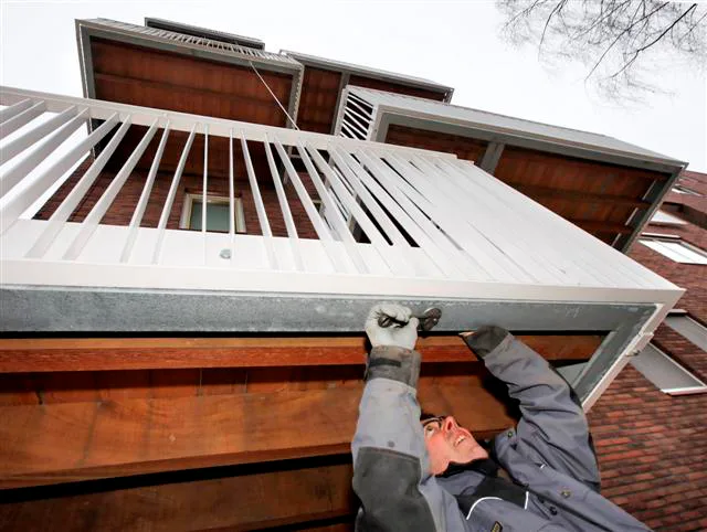 GEEN NAAM ONDER DE FOTO
Er zit beweging in de balkons aan de appartementencomplex in de Zwolse wijk Dieze-Oost. Bramer (de bouwer) is nu bezig dit te herstelen.
Bouwer Veenstra uit Schoonebeek (balkons) zegt dat er niks mis mee is.
Er worden nu spankabels geplaatst tussen de balkons.
