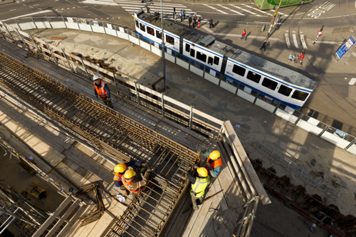 Nederland, Amsterdam, 27 maart 2012.










Aanleg Noord-Zuidlijn van de Amsterdamse Metro.




Het werkterrein aan de Prins Hendrikkade, ter hoogte van Brug 303. 
Op het werkterrein aan de Prins Hendrikkade wordt het laatste caisson van de Noord/Zuidlijn gebouwd.
Het caisson steunt op ‘snijranden’, twee meter hoge randen aan de onderzijde ervan. Ze zorgen ervoor dat
het caisson straks makkelijk de grond in zakt. 

Nu wordt op het dak van het caisson een twaalf meter hoge schacht gebouwd.
Tijdens het afzinken van het caisson, dat volgens de huidige planning in mei begint,
wordt al het benodigde materiaal via deze schacht aangevoerd. De bouw van de schacht
duurt een maand.

The City of Amsterdam is building a new subway (underground) line.
The tunnel is partly constructed underneath the old part of the city.
The completion of the metro line is scheduled for 2017.






Foto: Ge Dubbelman/Hollandse Hoogte. 
Opdrachtnummer: D10023