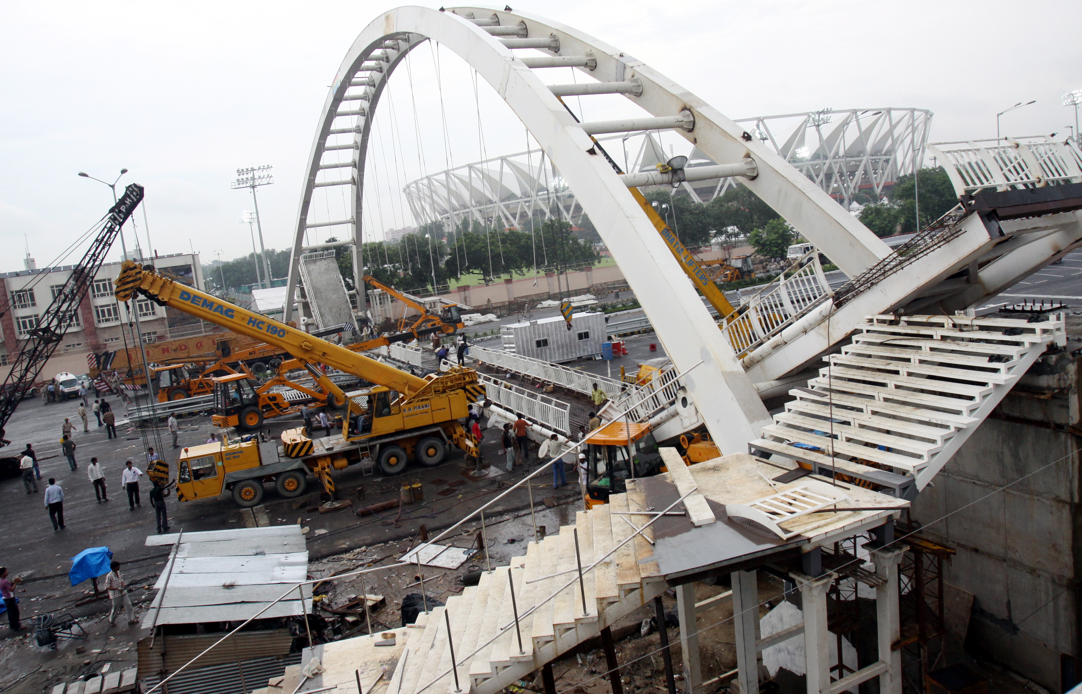 epa02349764 Construction workers work to remove debris from a footover bridge that collapsed near Jahawarlal Nehru Stadium in New Delhi, India on 21 September 2010. According to media reports  23 people are reported to be injured.  The Commonwealth Games Delhi 2010 are scheduled to be held in Indian capital New Delhi from 03 October to 14 October 2010.  EPA/ANINDITO MUKHERJEE