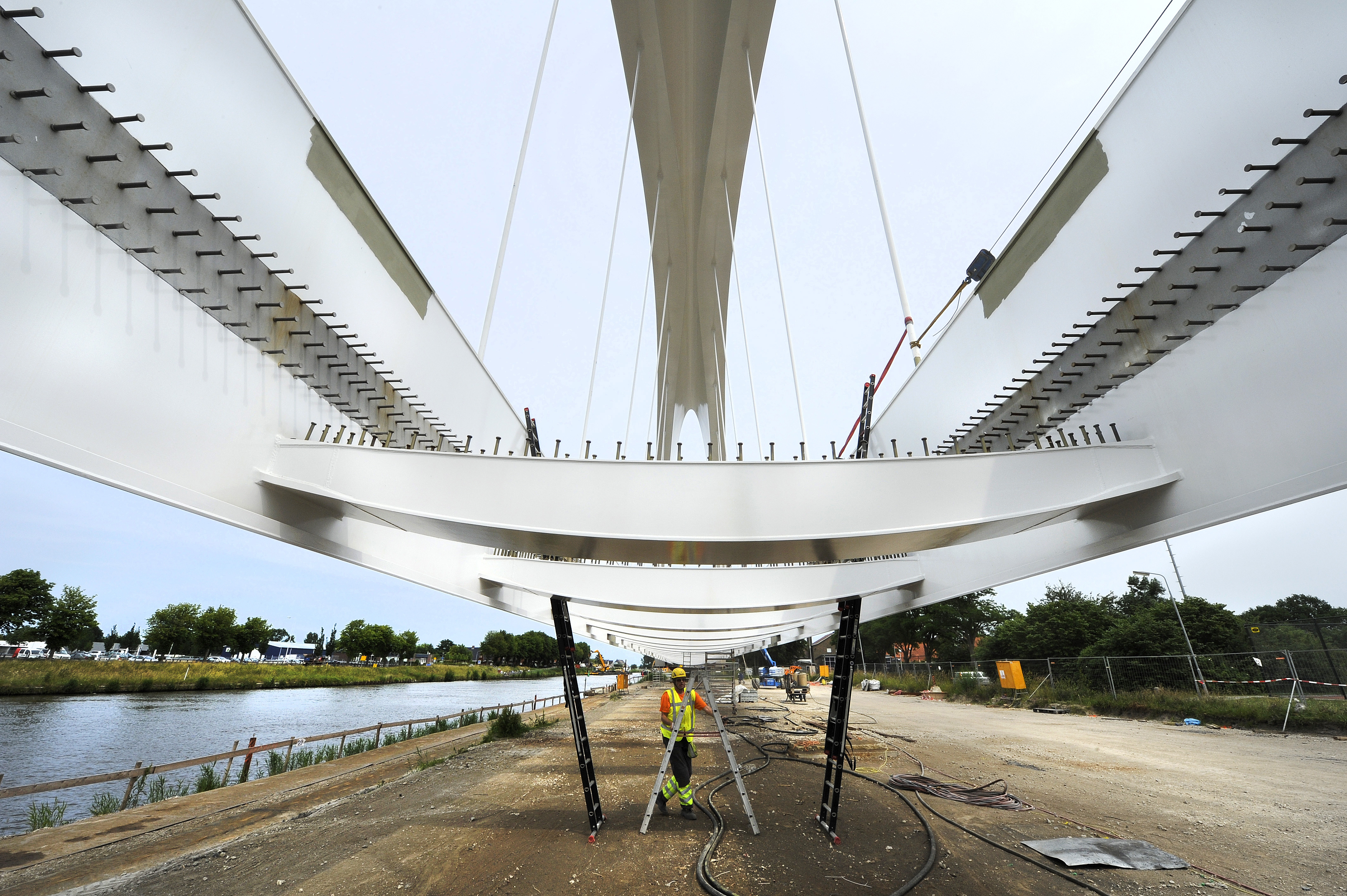 Het plaatsen van de nieuwe spoorbrug  bij Zuidhorn wordt een huzarenstukje. De 38 meter hoge boog staat pal naast het Van Starkenborghkanaal opgesteld en wordt 8 juli door Mammoet op zijn plek gereden. (Foto: Alex de Haan)