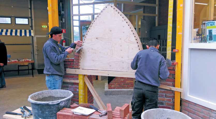 Mitchell de Vries bezig met metselwerk aan het ROC Amsterdam 