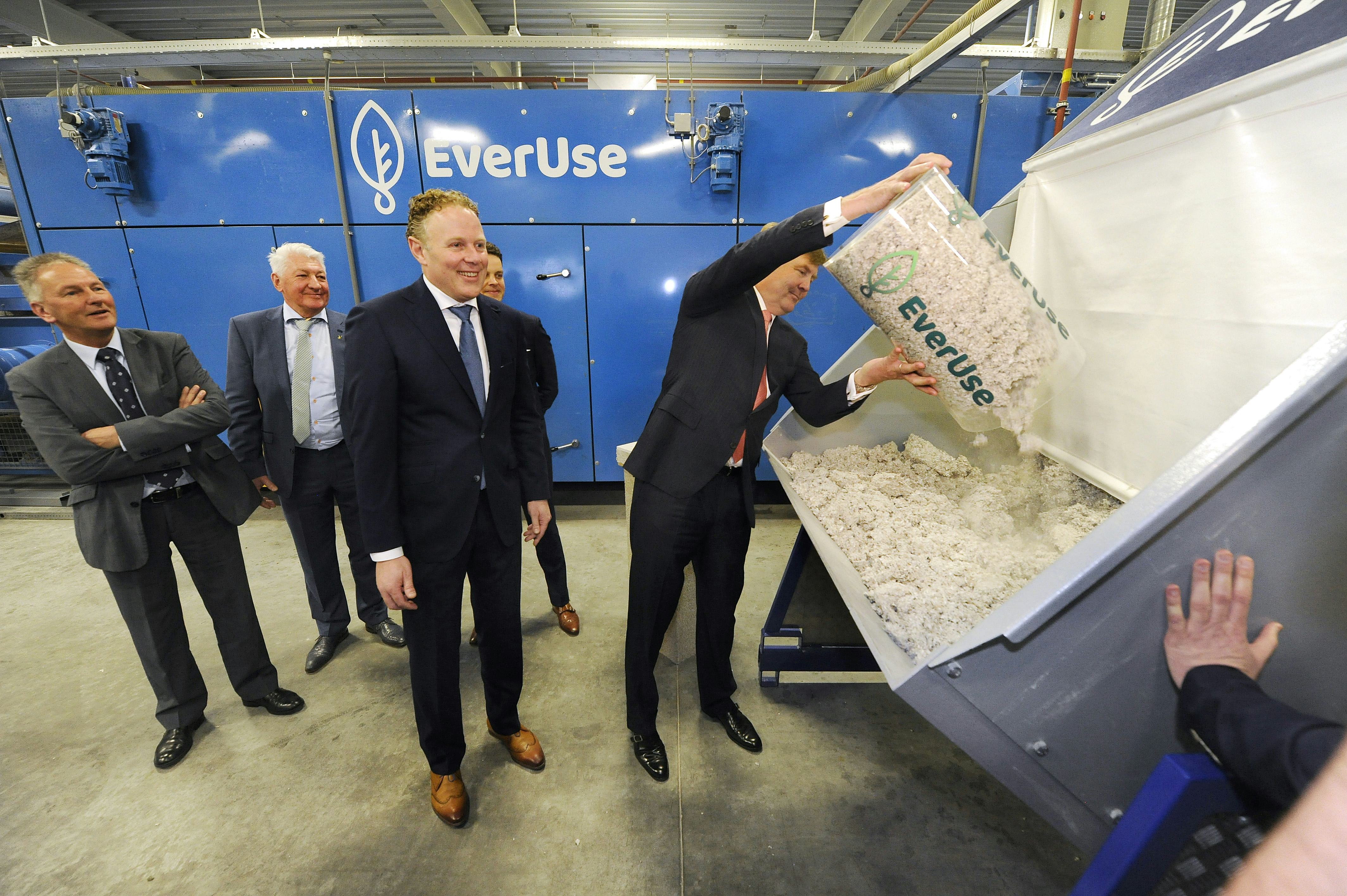 Met een ferme zwaai deponeert koning Willem-Alexander een tonnetje cellulose in de grote pers voor isolatieplaten. De directie van het Sneker bedrijf Everuse staat glunderend te kijken. De officiële opening van de eerste circulaire isolatiemattenfabriek was met die handeling een feit. 
Het bedrijf maakt isolatiemateriaal van oudpapiersnippers en neemt de materialen aan het eind van de levensduur weer terug. In elk mat zit daarom een chip met informatie over de maker. 
Willem-Alexander kreeg een rondleiding door de fabriek, waar de schoongemaakte papiersnippers machinaal met lijm worden vermengd. Hij zag hoe in een grote pers de isolatiemat  wordt gevormd en vervolgens op maat gesneden. Afhankelijk van de toepassing wordt aan een zijde een gipsplaat geplakt. Met een zwarte viltstift zette hij vervolgens zijn koninklijke handtekening op een mat, waarvan hij de grondstof zelf in de machine had gedaan.
Everuse ziet de circulaire matten als volwaardig alternatief voor bestaand isolatiemateriaal. ,,Het materiaal is gezond voor de verwerkers en de eindgebruikers'', aldus de directeuren in hun gesprek met de koning. De Sneker ondernemers willen de platen exporteren en hebben inmiddels contacten met architecten en bouwers in het Verenigd Koninkrijk, Spanje, Frankrijk en België.