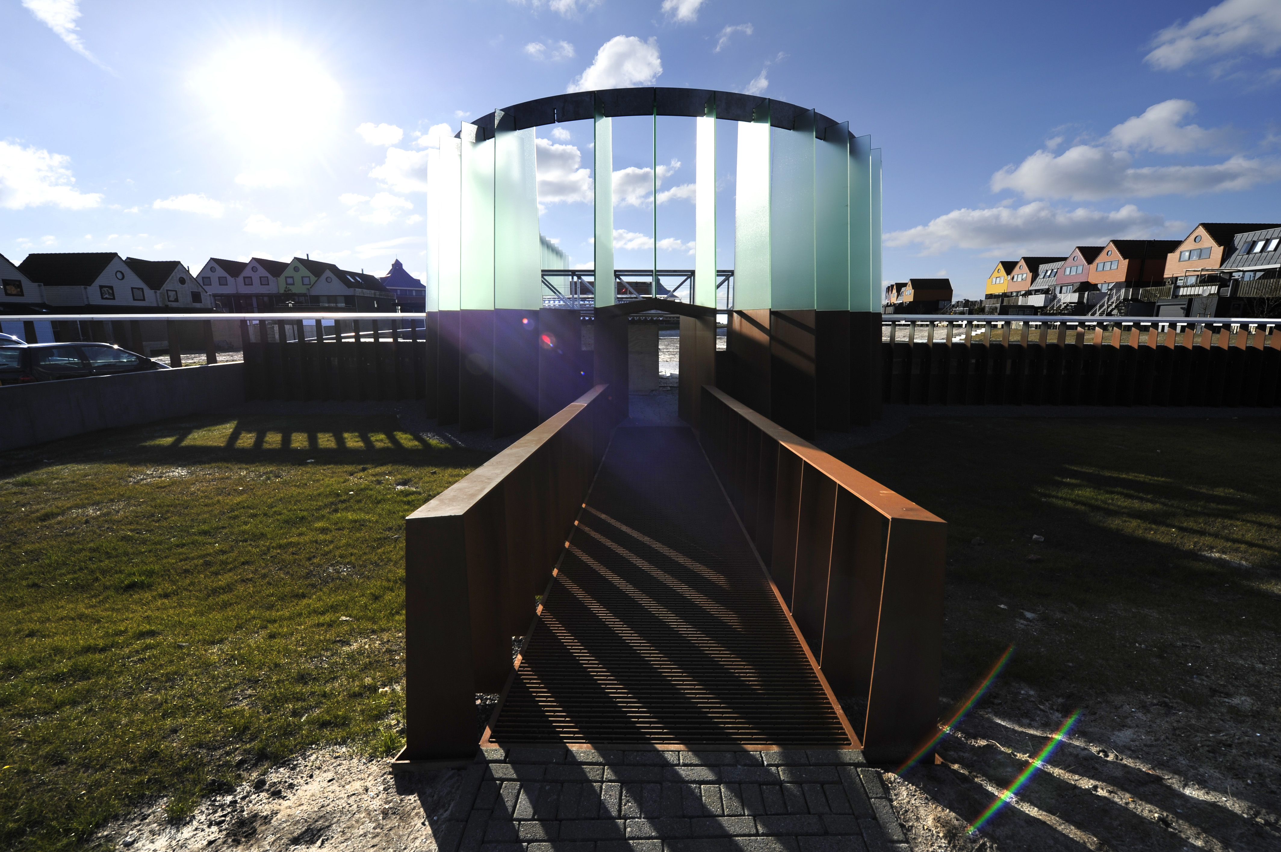 De replica van een blokhuispoort uit 1522 in Stavoren in cortenstaal en glazen lamellen staat er al. De contouren van de vroegere muren zijn aangegeven in een constructie van anderhalf meter hoogte met een stalen puntdakje. Tachtig bij tachtig meter. Pal achter de woningen van bewoners in Stavoren, die protest aantekenden.  De gemeente Súdwest-Fryslân heeft echter illegaal een kunstwerk laten bouwen. De rechter vernietigde twee omgevingsvergunningen na protest van omwonenden. Een nieuwe vergunningsaanvraag is in de maak.