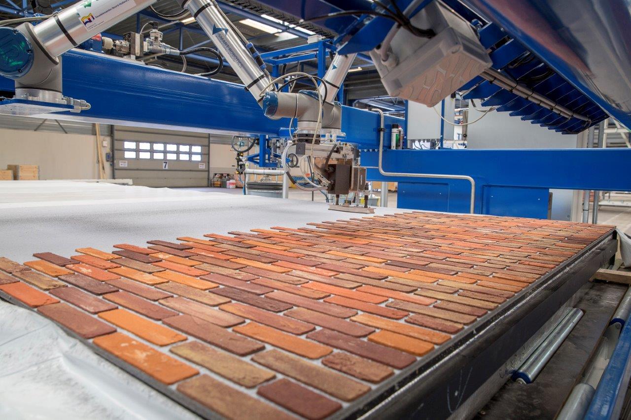 De gevel-robot aan het werk. In één uur een hele gevel. 