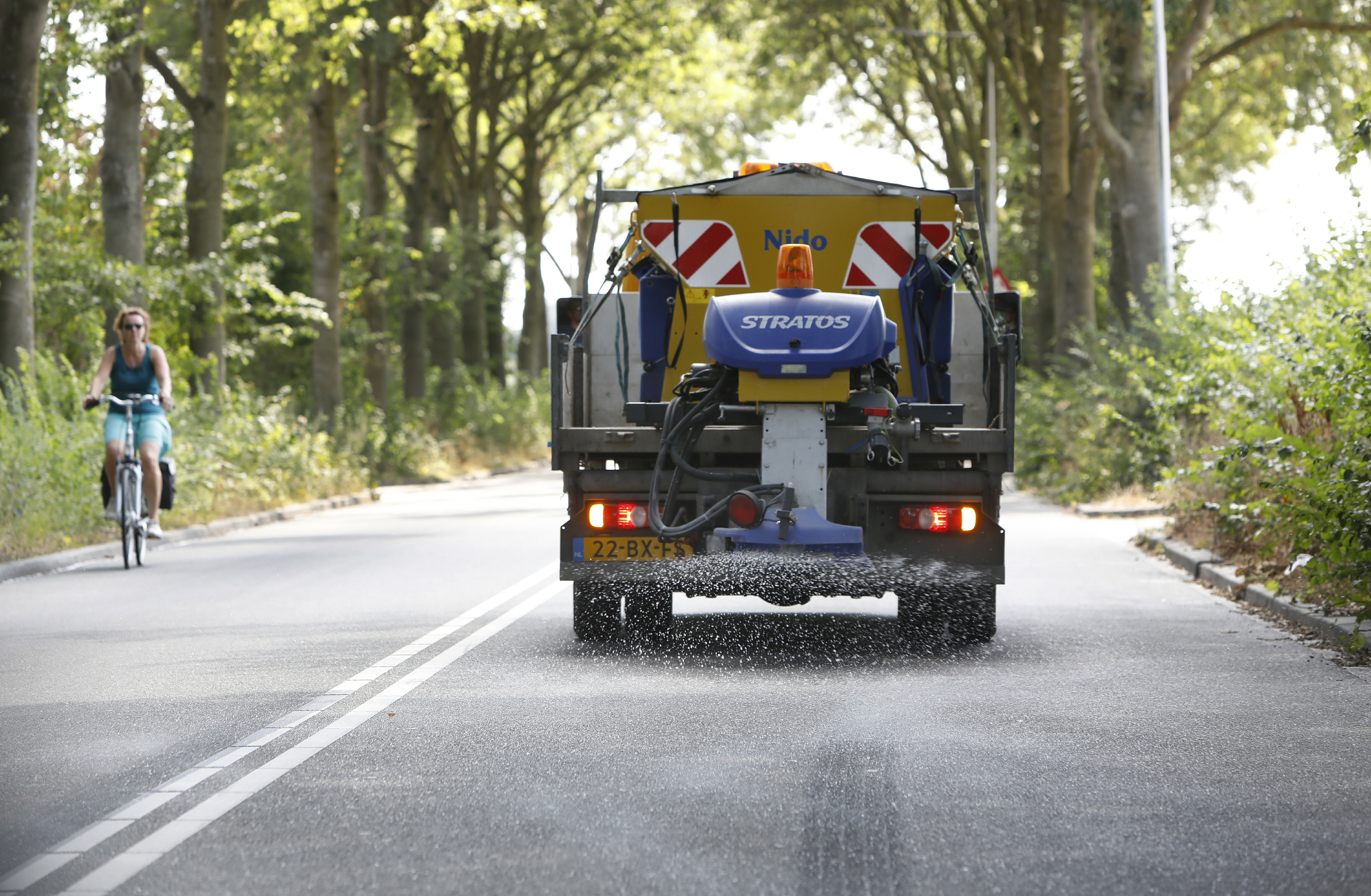 Foto: VidiPhoto

GELDERMALSEN – Het blijft een vreemd gezicht: zout strooien in de zomer. Maandag ging de strooiwagen van de gemeente Geldermalsen opnieuw op pad om het asfalt op een aantal wegen te verkoelen met zout. Temperaturen lopen met deze droogte en felle zon op vooral het donkere asfalt en in bochten soms op tot 80 graden Celsius, met als gevolg dat de bovenlaag smelt en wegen beschadigd raken. Zout zorgt voor een chemische reactie waardoor de temperatuur van het asfalt daalt. Hoewel provincies en Rijkswaterstaat op hun wegen hetzelfde truukje toepassen, is Geldermalsen -volgens een woordvoerder- de enige gemeente die haar wegen op deze wijze beschermt. Daarmee worden honderdduizenden euro’s aan onderhoud bespaard. De baten zijn vele malen groter dan de kosten van het zout.
