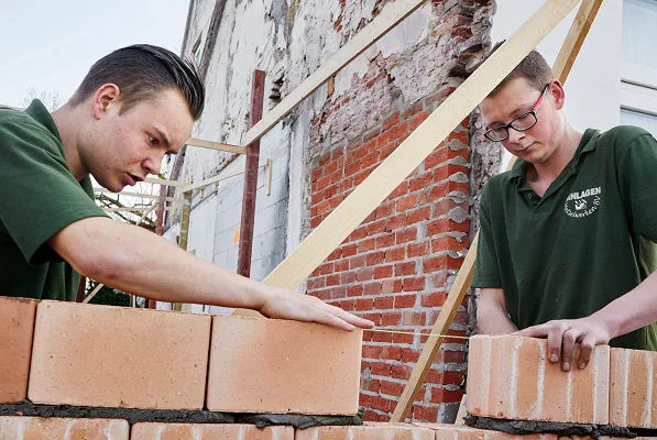 Erik Hop (rechts met bril) en Robin Joosten, leerling metselaars, aan het werk bij een renovatieproject in Loenen aan de Vecht.
Foto: Christiaan Krouwels