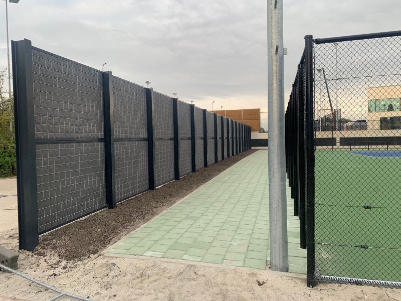 Kokowall HA-Minwol geluidsscherm H=3,5m – H=4,2m en L=155m bij ‘Tenniscentrum De Kegel’ te Amstelveen langs tennisbanen geplaatst op maaiveld en op het dak van de parkeergarage.