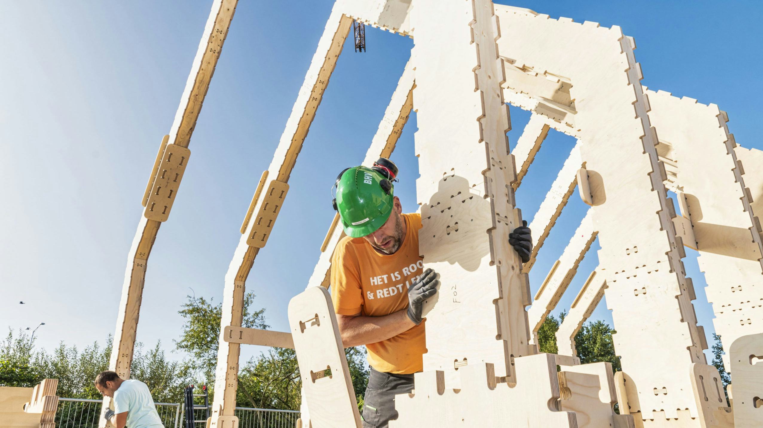 Zelfbouwer Sebastiaan Vos stoeit op de bouwplaats in Almere met een dakspant. Foto: Maarten Veenstra