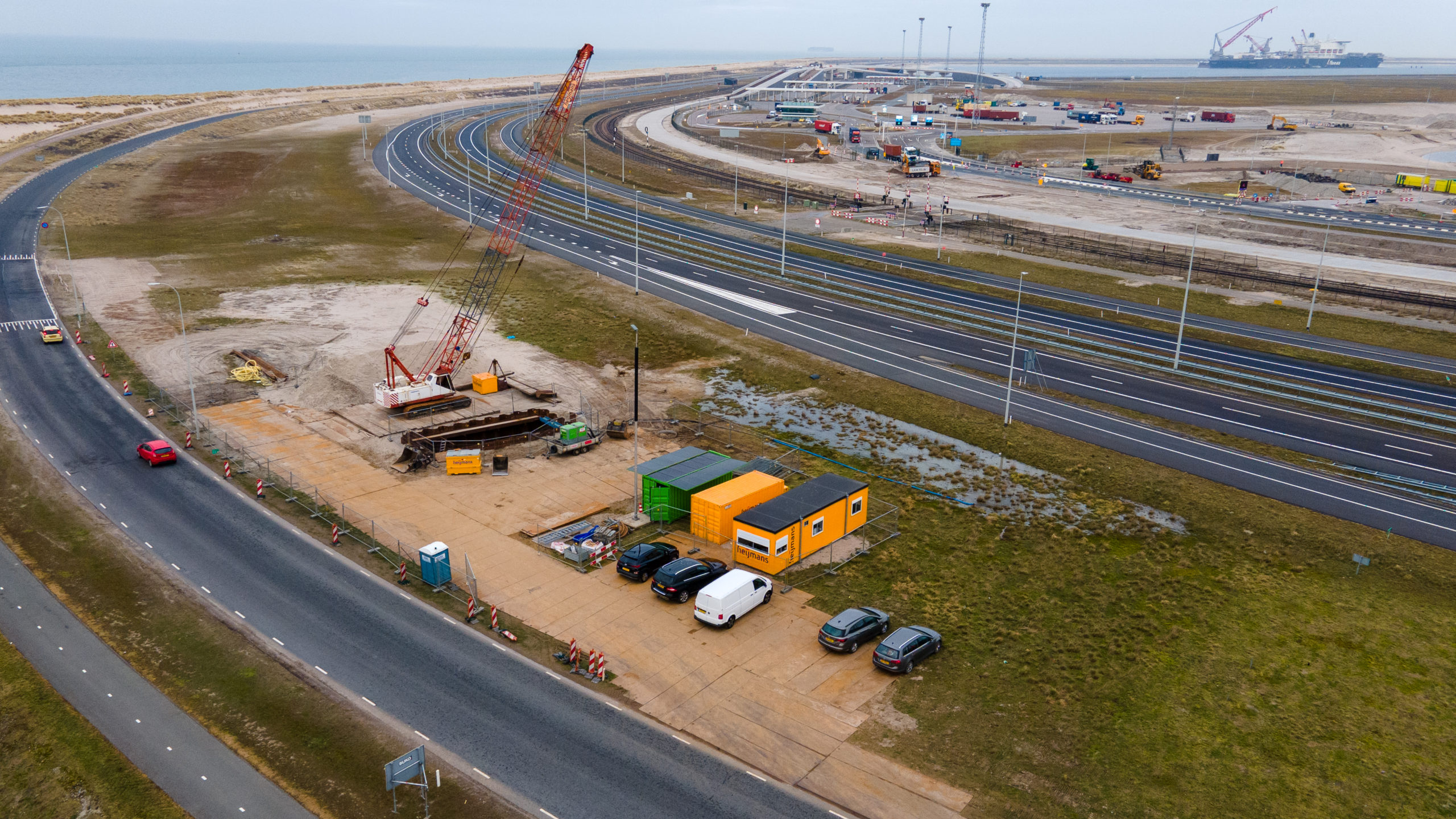 Heijmans Infra regio Zuidwest startte de pilot in februari op de Maasvlakte. Het bedrijf bouwt daar een grote duikerverbinding. Naast de twee gele bouwketen bevindt zich de gifgroene accucontainer. Foto: Inge Jansen