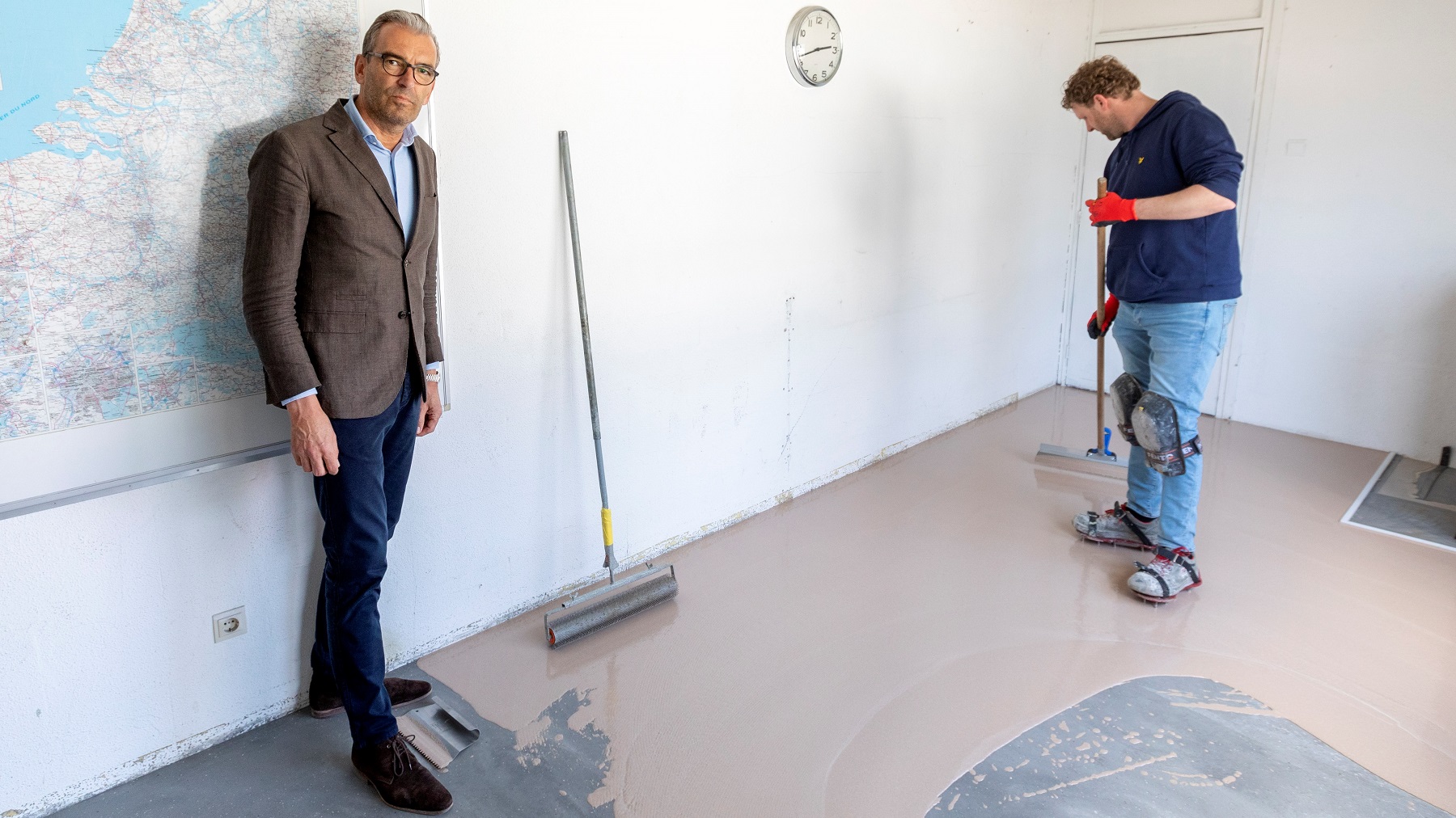Jeroen van den Berg (links) tijdens het aanbrengen van Corques. "Dit is linoleum"
Foto: Guido Benschop
