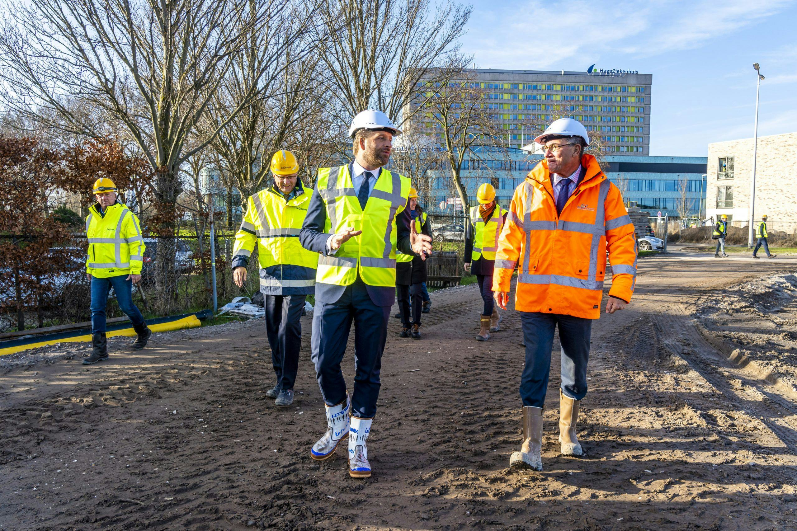 Minister De Jonge tijdens een rondleiding op een bouwplaats in Den Haag. Foto: ANP/Lex van Lieshout
