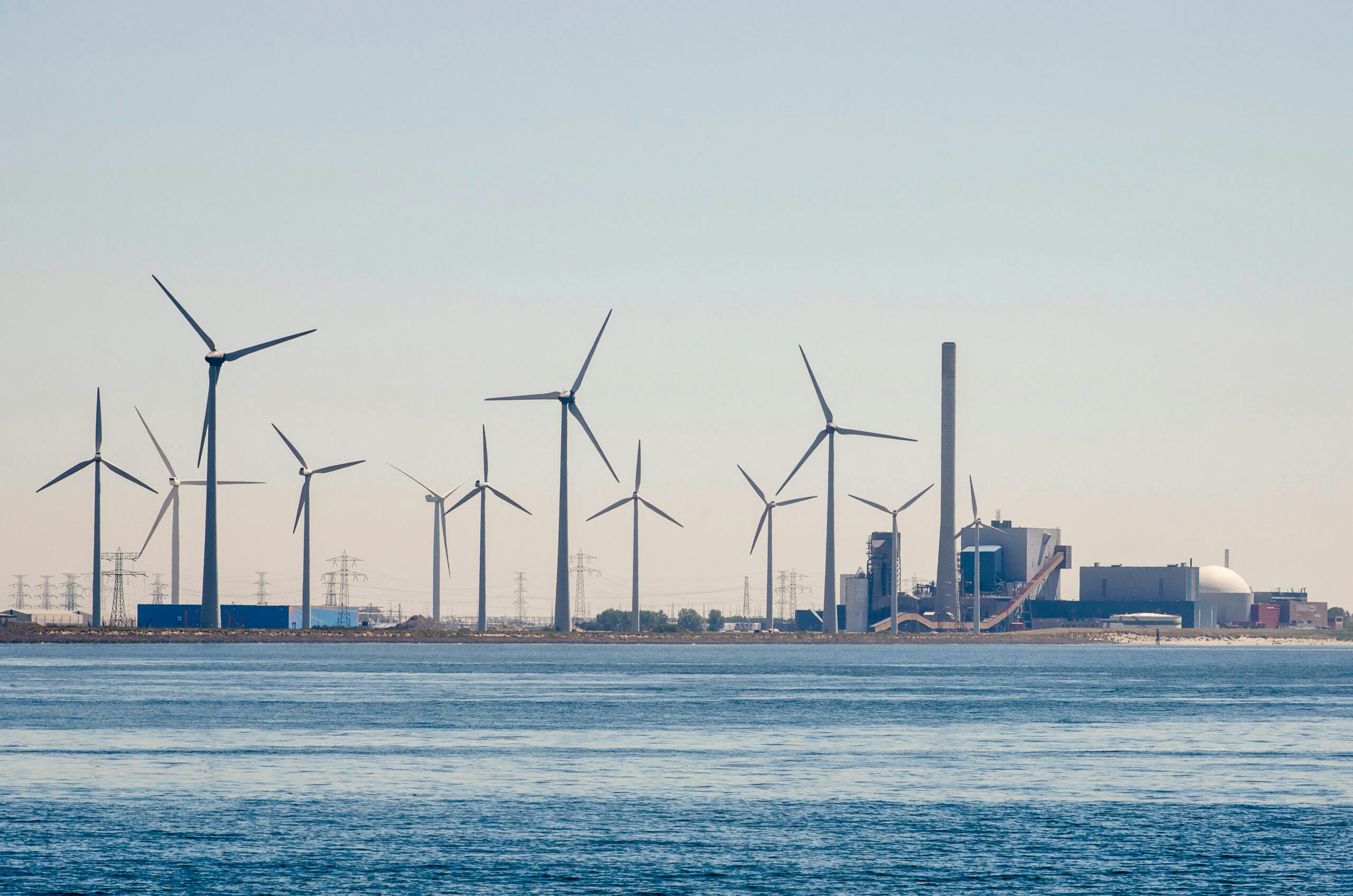 Windmolens met op de achtergrond de kerncentrale van Borssele. In Zeeland staan grote uitgaves aan kerncentrales gepland. Foto: Shutterstock