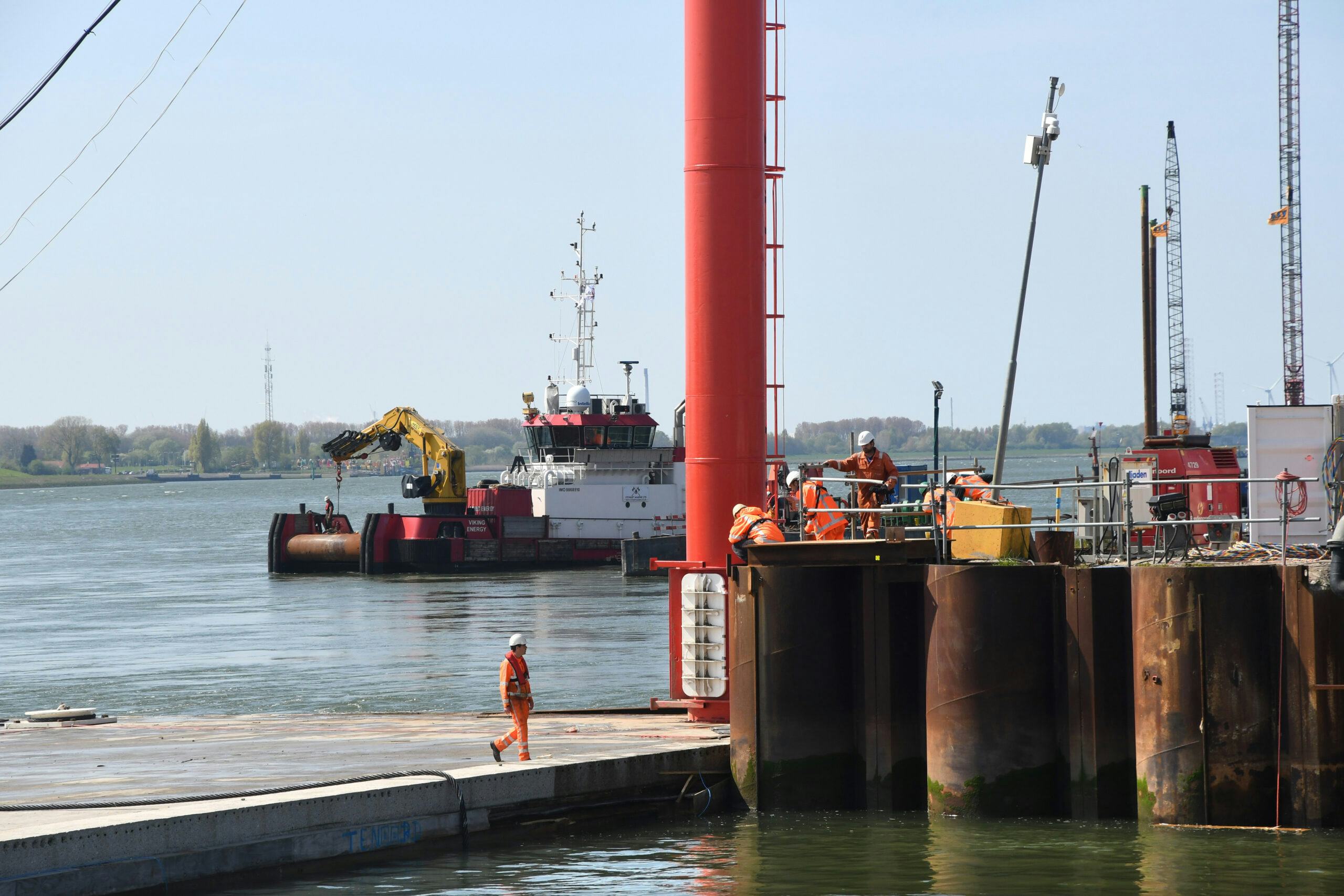 Medewerkers van combinatie BAAK bekijken de schade nadat het tunnelelement tegen de buispalenwand knalde. Foto: Ries van Wendel de Joode