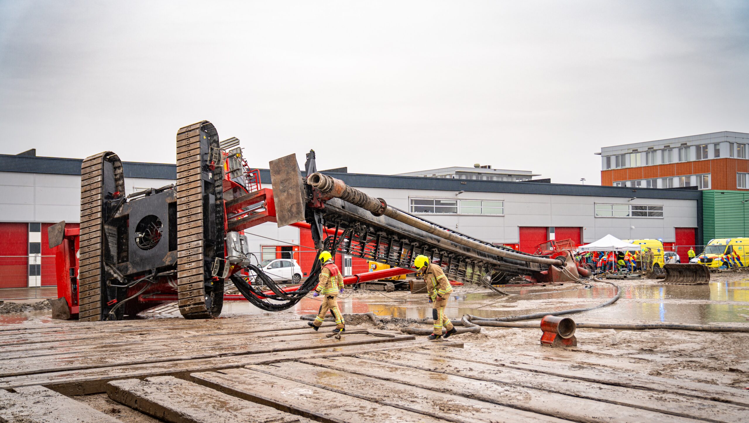Brandweermannen inspecteren de omgevallen heistelling op het industrieterrein Waalhaven. Foto: Kilian Lindenburg/MediaTV