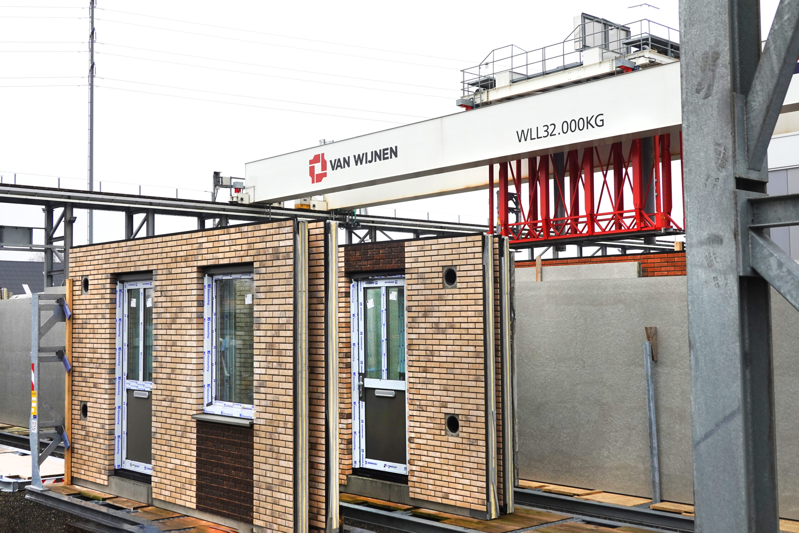 Volledig geautomatiseerd worden de gevels vanuit de woningfabriek van Van Wijnen Groep in Heerenveen naar het opstelveld getransporteerd. Foto: Alex J. de Haan