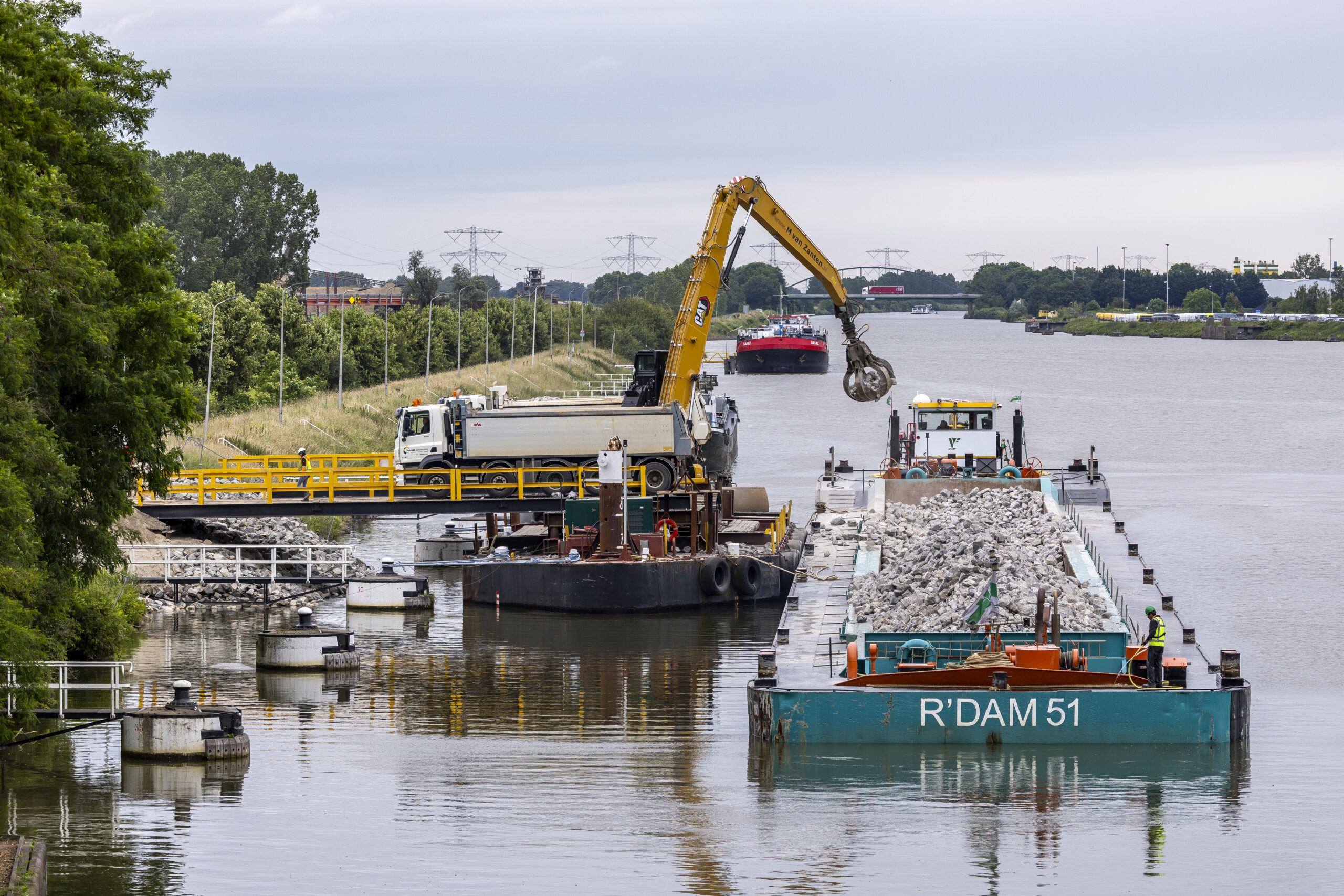 Afgelopen weken is er koortsachtig materiaal aangevoerd voor de verruiming. Het ligt in depot langs de oevers van het Julianakanaal.  Foto: Marcel van Hoorn.