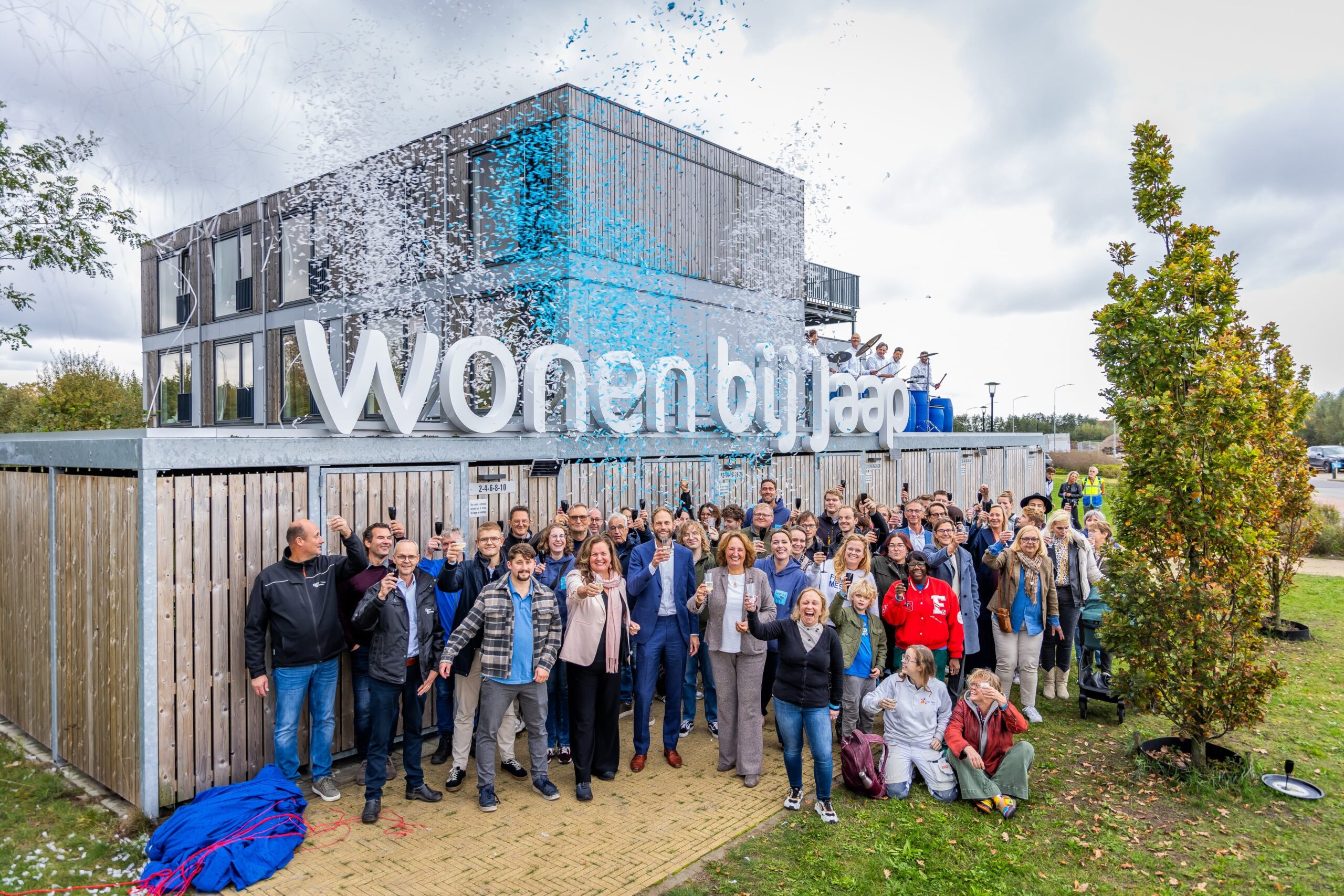 Bewoners en bestuurders vieren de officiële opening van de woningen in Nijkerk.