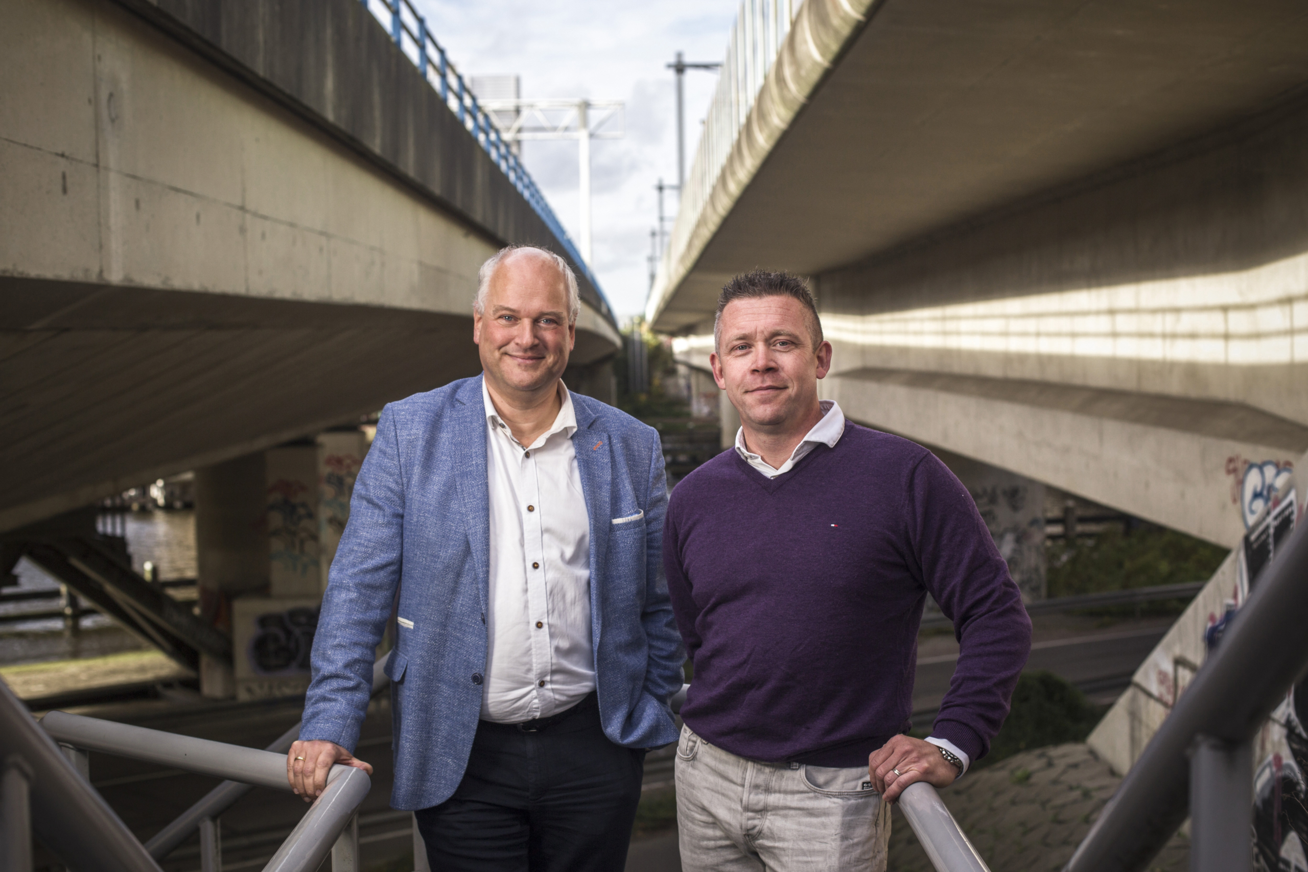 Projectmanagers Ferdinand Bockhoudt (links) en Rik van Opdorp bij de Rozenoordbrug. De klok tikt bij deze brug over de Amstel, die uiterlijk in 2032 vervangen moet zijn. Foto: Eran Oppenheimer