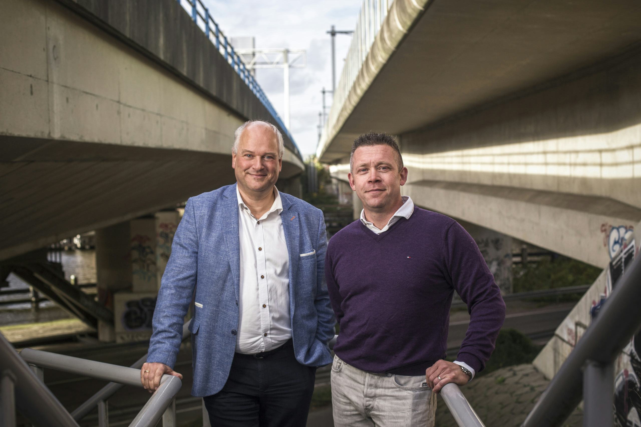 Projectmanagers Ferdinand Bockhoudt (links) en Rik van Opdorp bij de Rozenoordbrug. De klok tikt bij deze brug over de Amstel, die uiterlijk in 2032 vervangen moet zijn. Foto: Eran Oppenheimer