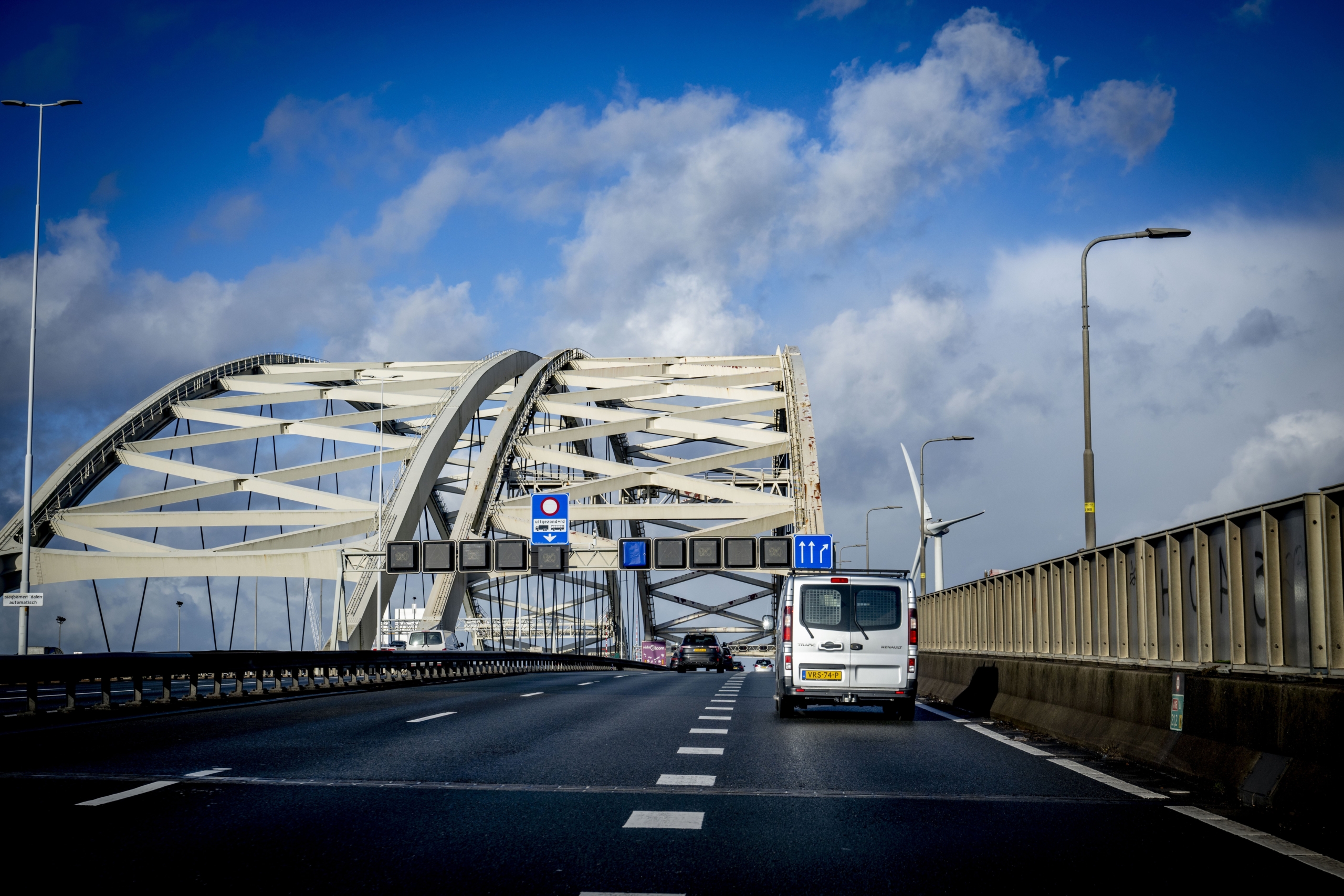 De Van Brienenoordbrug gezien vanuit het zuiden. De westelijke  boog (links) dateert van 1990 en moet in 2030 worden uitgetild en vervangen door een hagelnieuw exemplaar. Na versterking op een eiland bij Dordrecht wordt hij twee jaar later op de plaats van de oostelijke boog gelegd. Die boog uit 1965 wacht waarschijnlijk sloop. Foto: ANP / Robin Utrecht
