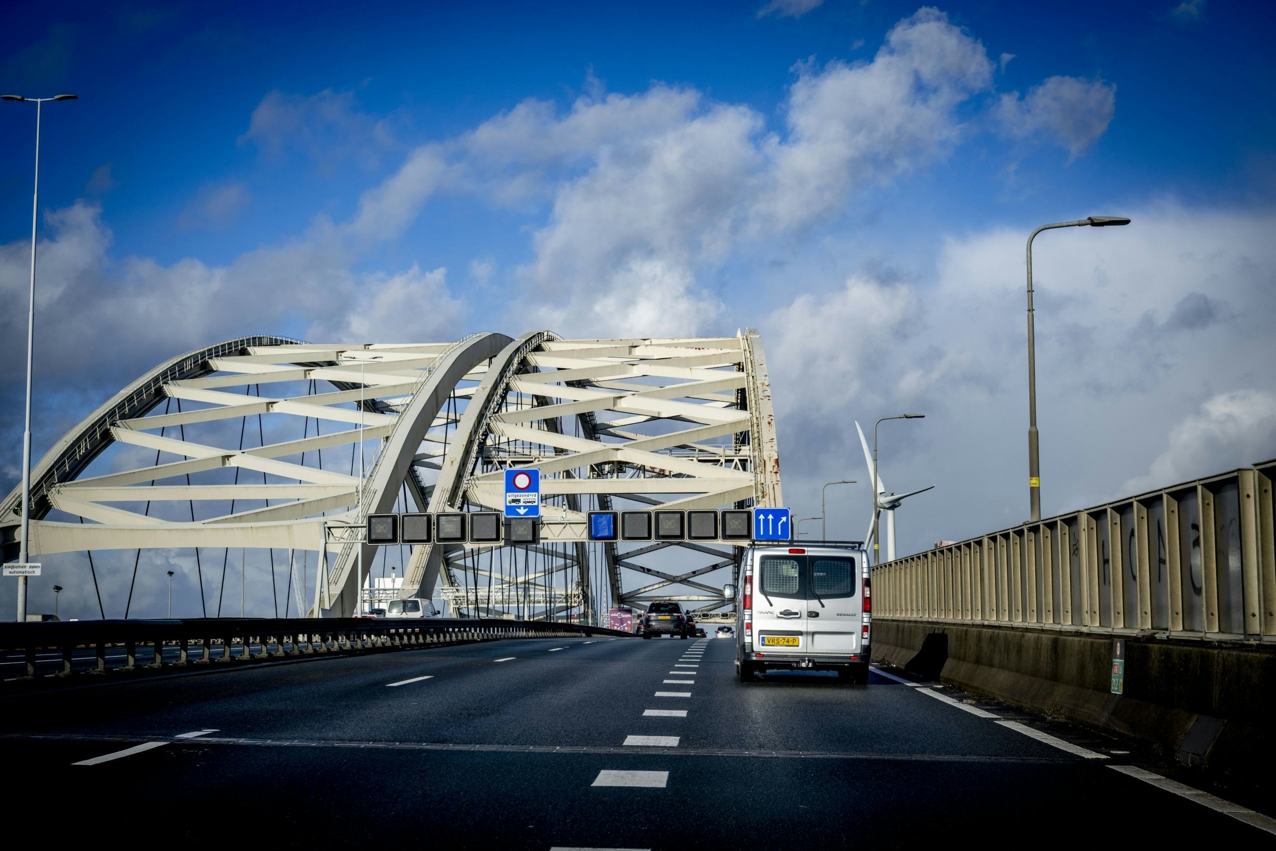 De Van Brienenoordbrug gezien vanuit het zuiden. De westelijke boog (links) dateert van 1990 en moet in 2030 worden uitgetild en vervangen door een hagelnieuw exemplaar. Na versterking op een eiland bij Dordrecht wordt hij twee jaar later op de plaats van de oostelijke boog gelegd. Die boog uit 1965 wacht waarschijnlijk sloop. Foto: ANP / Robin Utrecht