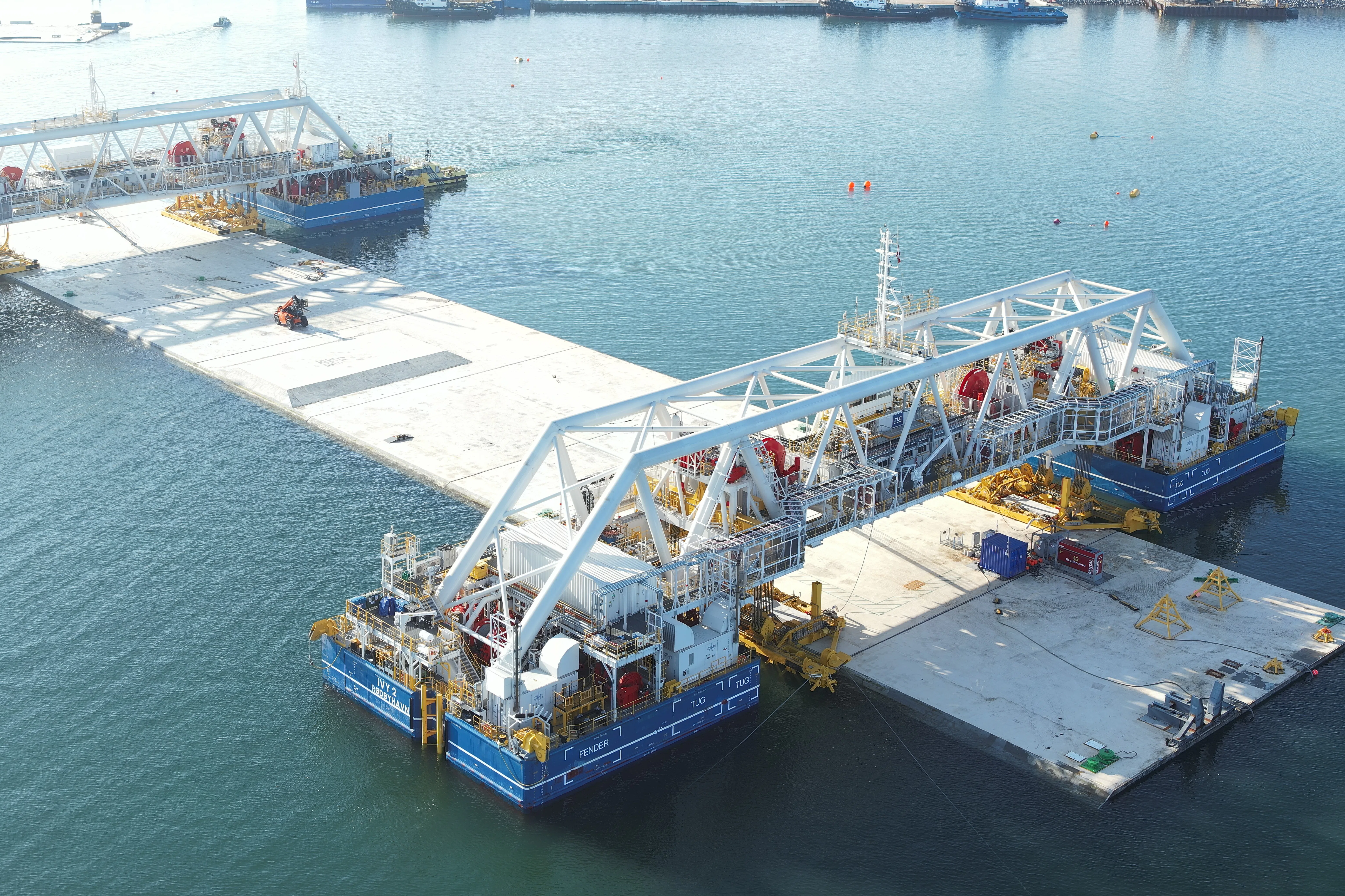 Afzinkpontons Ivy 1 en 2 zijn gekoppeld aan een tunnelelement in de werkhaven voor de tunnelfabriek op Lolland. Foto: Femern A/S
