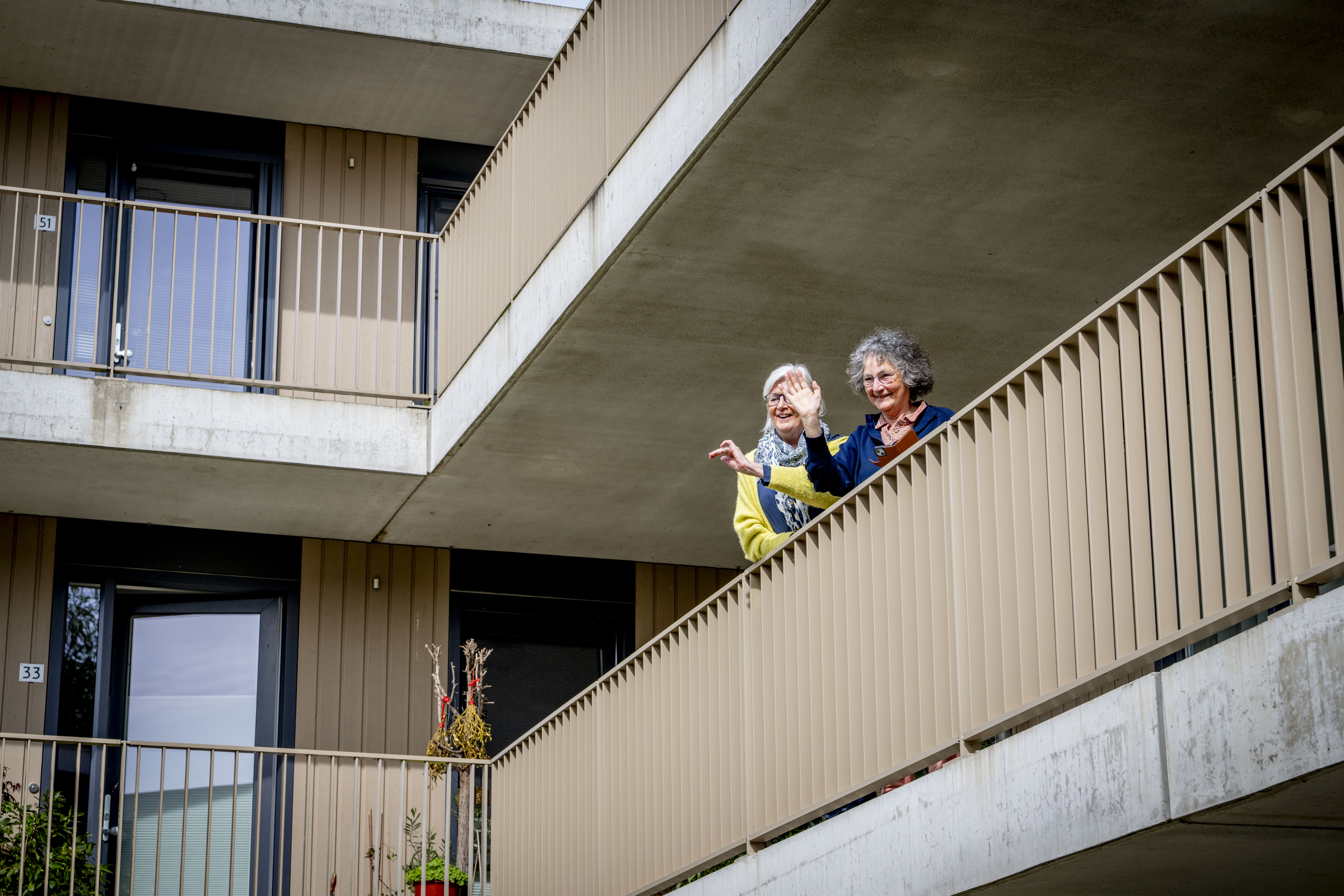 Twee bewoners staan op de galerij van het Knarrenhof in Gouda-Noord. Foto: Rijksoverheid - Robin Utrecht
