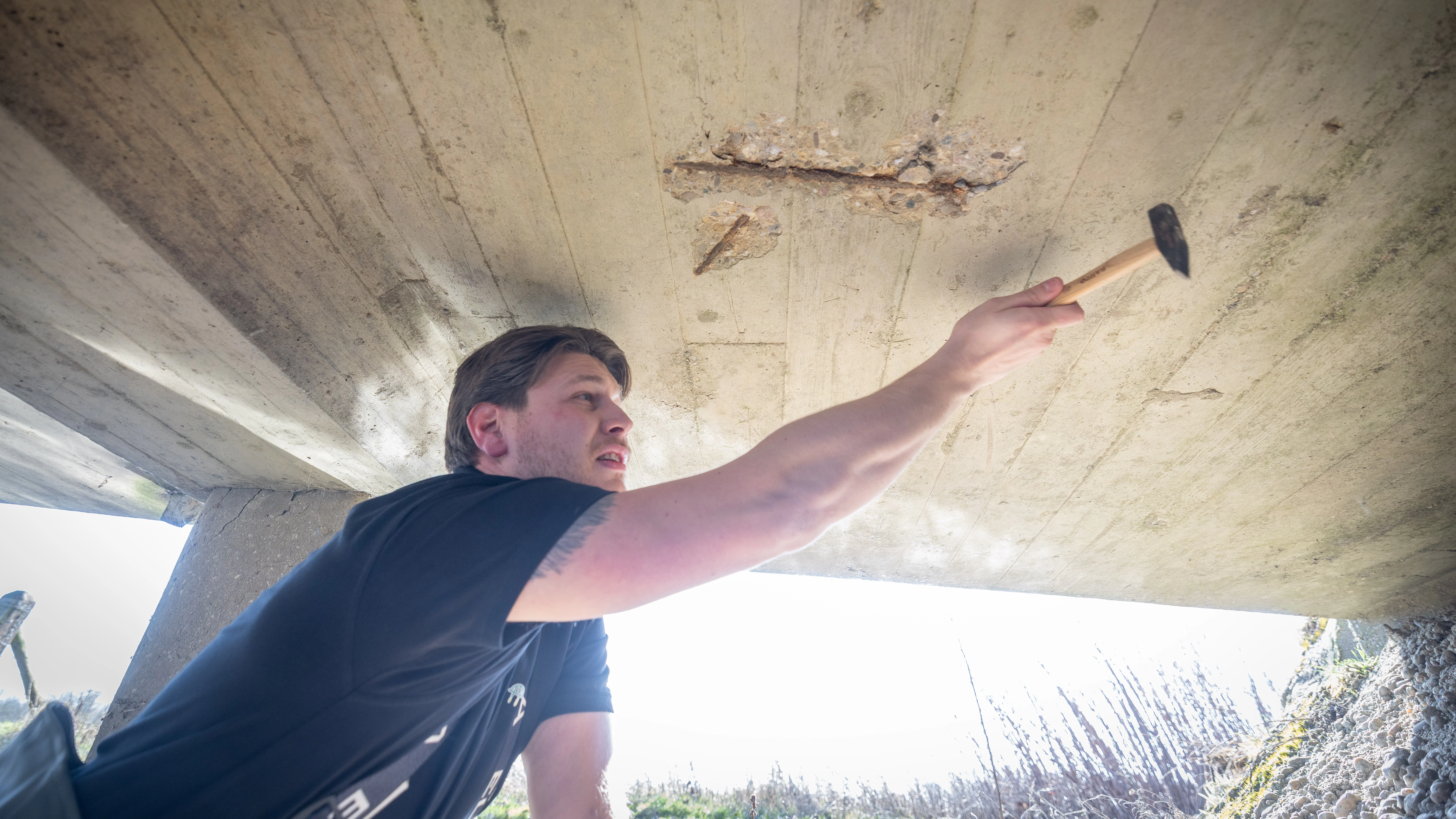 Als standaard accessoire heeft inspecteur Vincent Rietbroek een hamer mee om op betonnen bruggen te slaan. Een hol, metalig geluid betekent dat de wapening is losgeraakt. Foto: Sjef Prins/APA