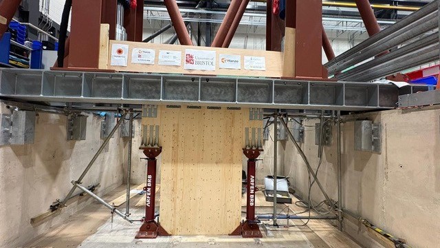 Het testgebouw bestaat slechts digitaal, op het kritische onderste stuk na. In het laboratorium in Bristol zijn echte CLT-wanden op zandgrond geplaatst. Foto: Hanzehogeschool