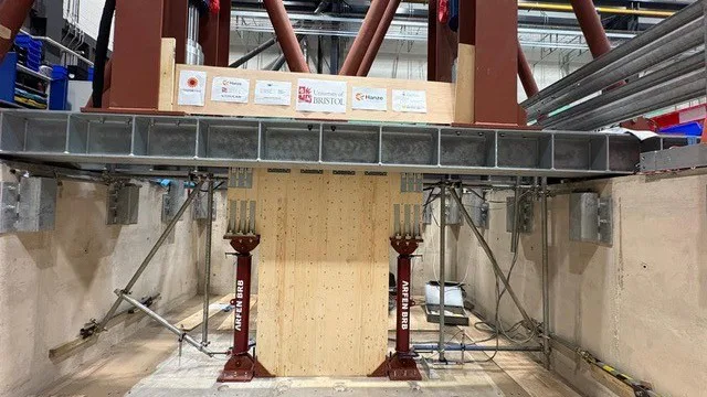 Het testgebouw bestaat slechts digitaal, op het kritische onderste stuk na. In het laboratorium in Bristol zijn echte CLT-wanden op zandgrond geplaatst. Foto: Hanzehogeschool