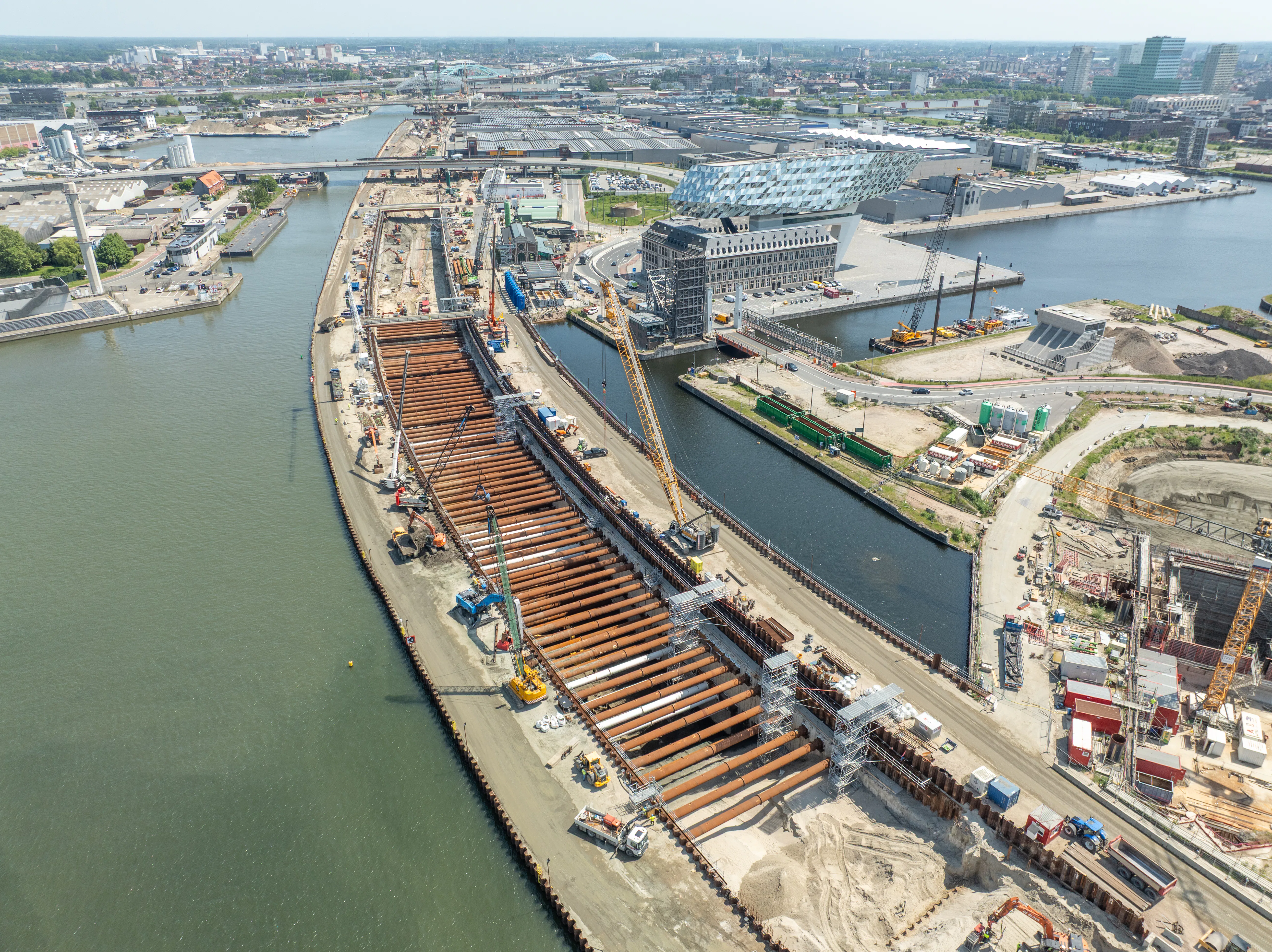 De langgerekte bouwput van de kanaalzonetunnel. Rechts het karkatteristieke Havenhuis van Antwerpen, met de blob van architect Zaha Hadid. Foto: Roco