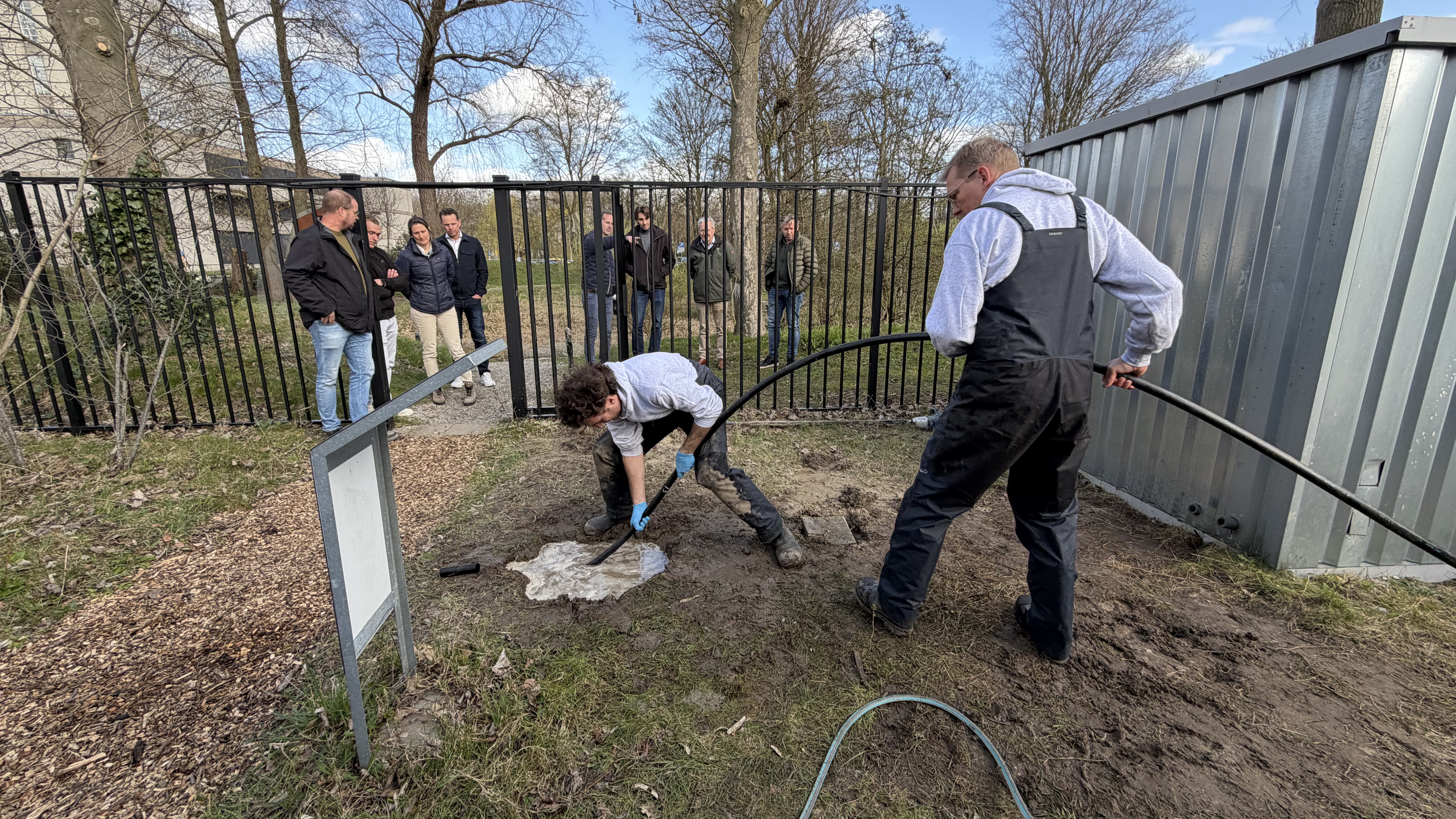 Het experiment met de boorinstallatie in The Green Village. De boring begint met het graven van een gat. Daar gaat een dikke tuinslang in, met een metalen uiteinde: de boorkop. Foto: GEHECO