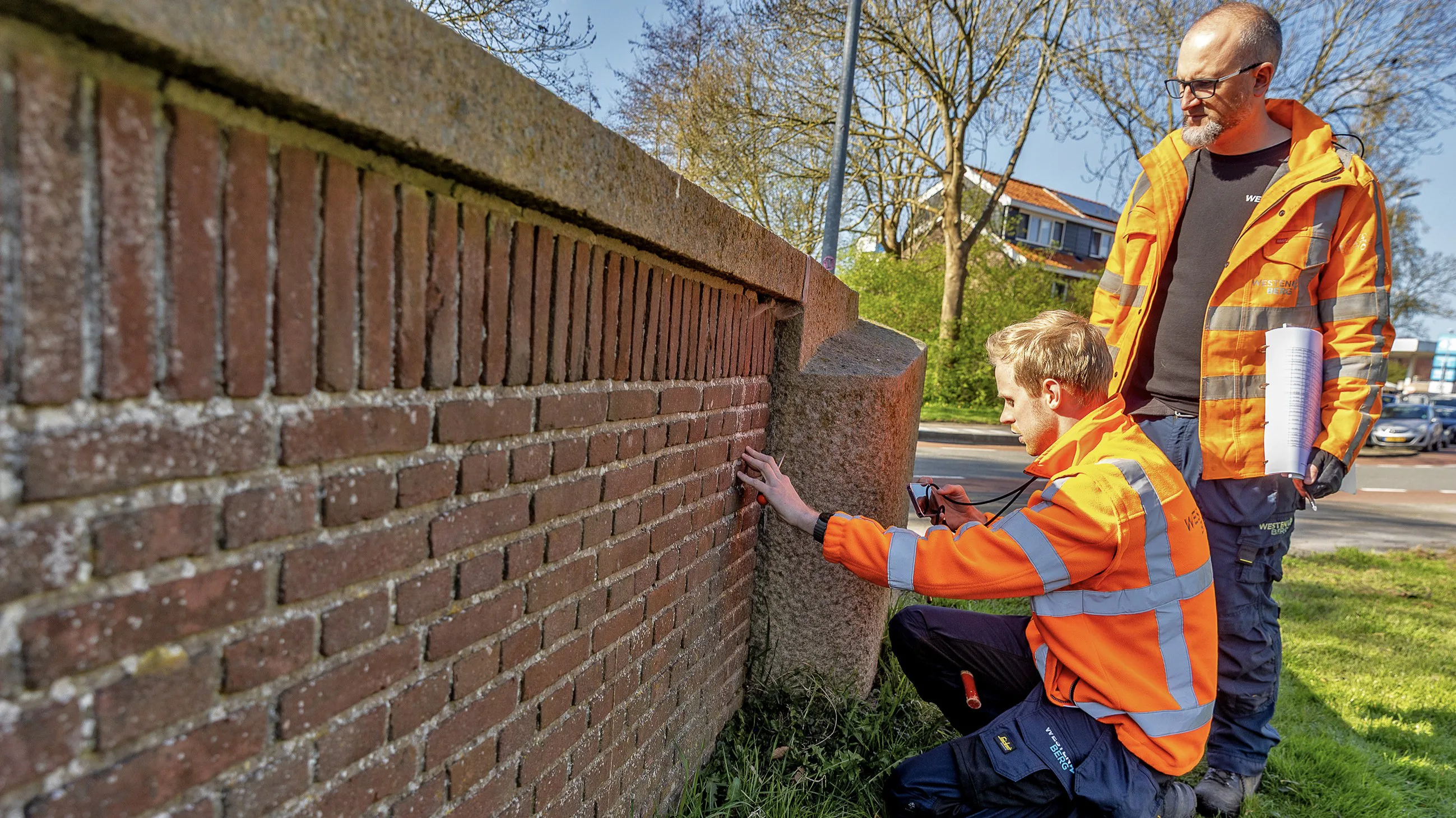 Wesley Koekoek (links) van ingenieursbureau Westenberg prikt met een schroevendraaier in het metselwerk van een brug in Alkmaar om te controleren of het nog goed vorm houdt. Foto: Vincent de Vries