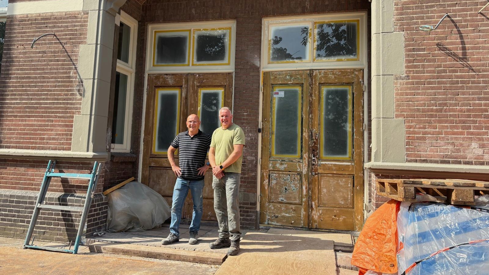 Hein de Kock (l) en Eric Vos (r) voor de hoofdingang van de Vondelschool. Foto: Britt Klijn