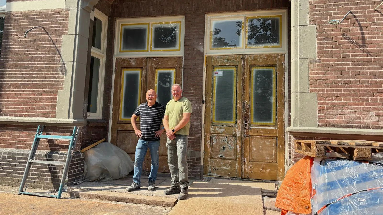 Hein de Kock (l) en Eric Vos (r) voor de hoofdingang van de Vondelschool. Foto: Britt Klijn
