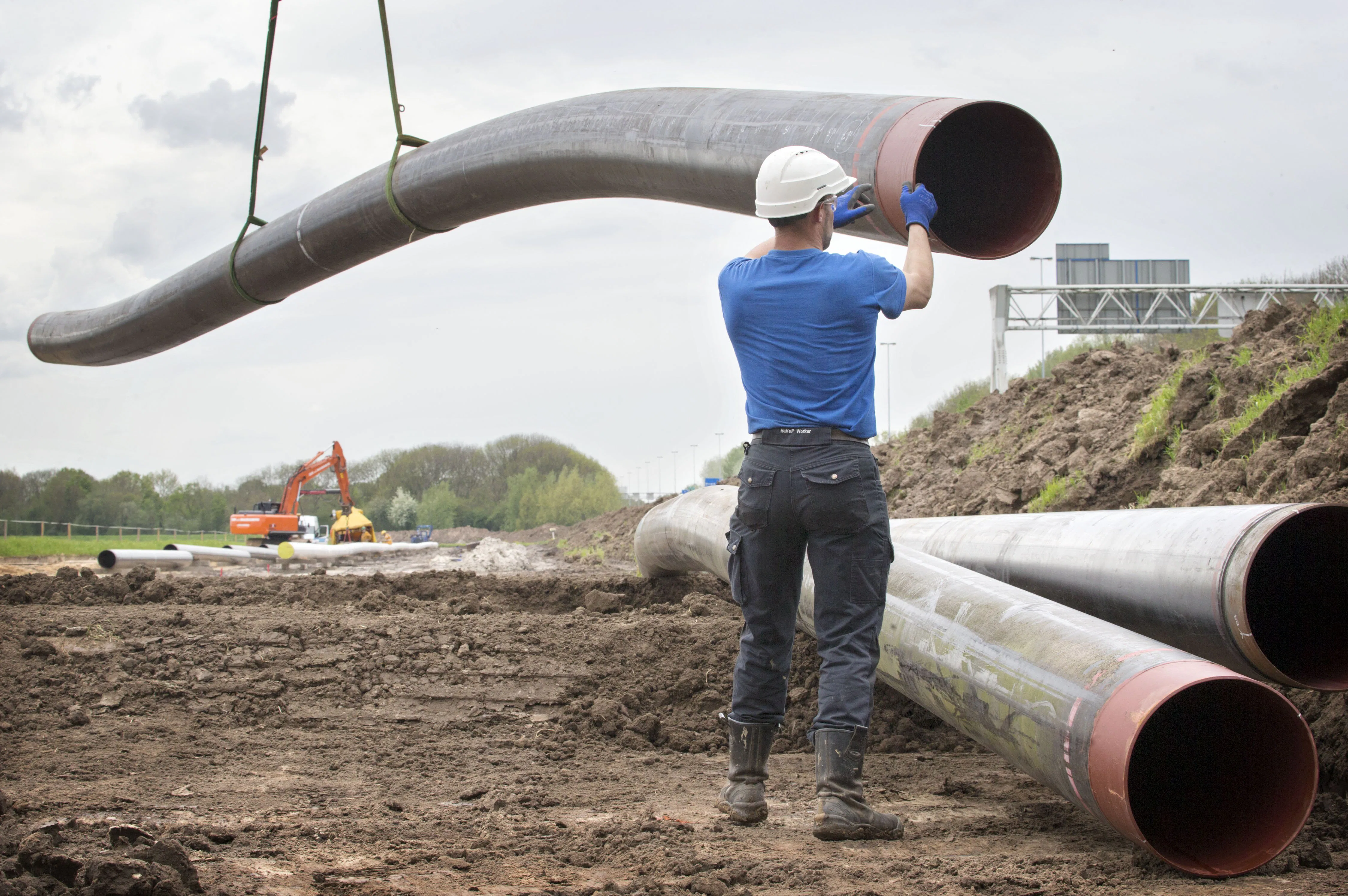 Een werknemer van A.Hak Leidingbouw is bezig met het verleggen van de gasleidingen naast de A27 bij Raamsdonksveer.
Foto: Joyce van Belkom/Hollandse Hoogte